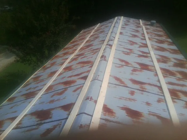 Rusted metal roof panels with new wood purlins before replacement — Storm Damage Roof Repair in Greenfield by Roofing Brothers